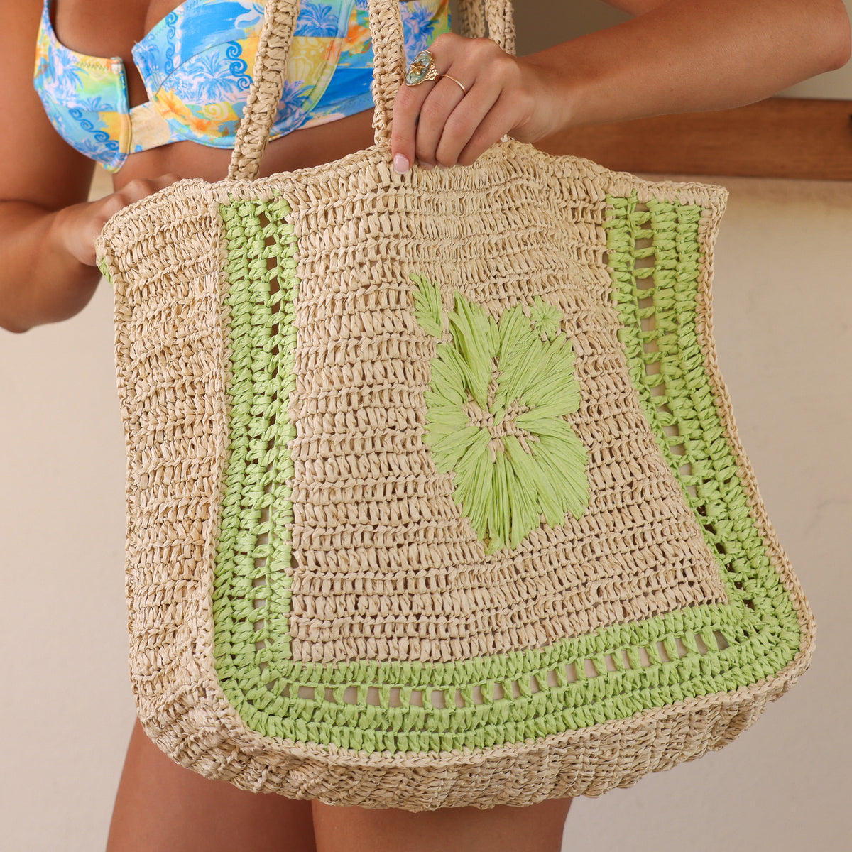 large straw tote with lime green hibiscus on it